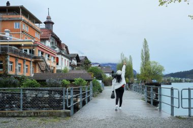 Kış kıyafetleri giyen Asyalı bir kadın, Brienz İsviçre 'nin manzarasının tadını çıkarıyor.