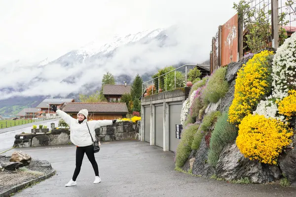 Kış kıyafetleri giyen Asyalı bir kadın, Brienz İsviçre 'nin manzarasının tadını çıkarıyor.