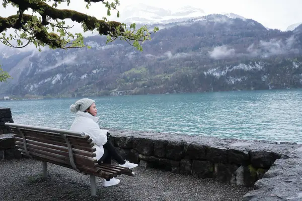 Brienz Gölü kıyısında bir kadın oturuyor, İsviçre