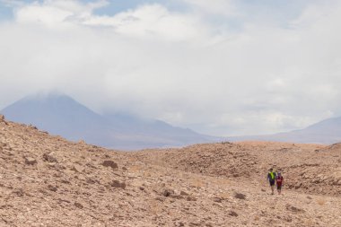 People hiking a mountain in the dryest part of Atacama, the most arid desert of the world