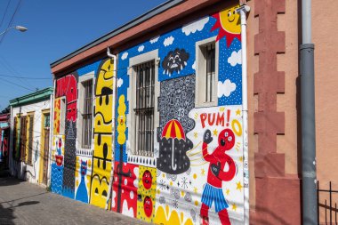 Valparaiso, Chile - Dec 5, 2022: Colorful houses full of graffiti on a steep street of Valparaiso, which has been declared as a World Heritage Site by UNESCO