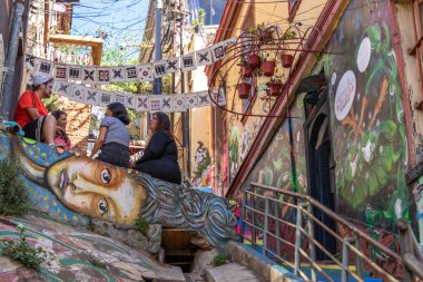 Valparaiso, Chile - Dec 5, 2022: Colorful houses full of graffiti on a steep street of Valparaiso, which has been declared as a World Heritage Site by UNESCO
