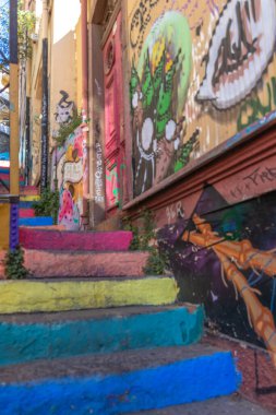Valparaiso, Chile - Dec 5, 2022: Colorful stairs and houses full of graffiti on a steep street of Valparaiso, which has been declared as a World Heritage Site by UNESCO