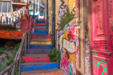Valparaiso, Chile - Dec 5, 2022: Colorful stairs and houses full of graffiti on a steep street of Valparaiso, which has been declared as a World Heritage Site by UNESCO