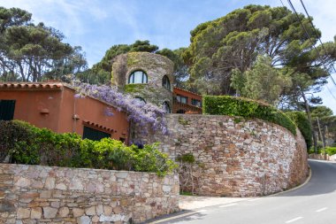 Begur, İspanya - 16 Nisan 2023: Şato gibi görünen lüks villa ve İspanya 'nın Kosta Brava kenti Begur yakınlarındaki bitki ve çiçeklerle dolu