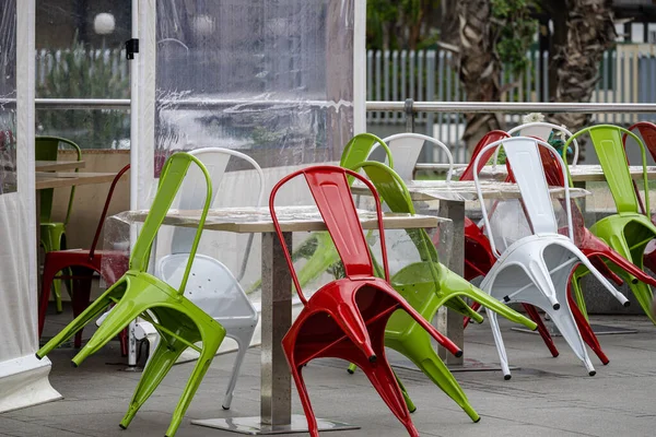 stock image Colored metal chairs supported on the tables of a bar