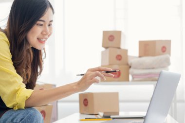 Küçük girişimciler, kahverengi paket kutuları, küçük ev kurma fikirleri olan ürünleri düzenleyerek bir ev kurarlar.