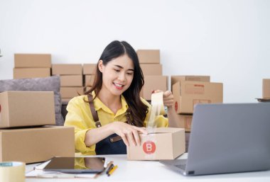 Küçük girişimciler, kahverengi paket kutuları, küçük ev kurma fikirleri olan ürünleri düzenleyerek bir ev kurarlar.