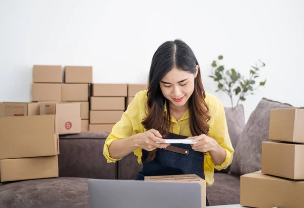 stock image Young woman taking pictures during packaging With a mobile phone or smartphone digital camera to post online sales on the Internet and prepare the product box pack. selling ideas online