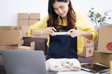 Küçük girişimciler, kahverengi paket kutuları, küçük ev kurma fikirleri olan ürünleri düzenleyerek bir ev kurarlar.