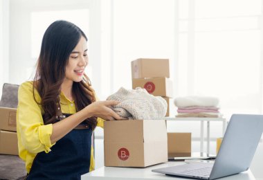 Küçük girişimciler, kahverengi paket kutuları, küçük ev kurma fikirleri olan ürünleri düzenleyerek bir ev kurarlar.