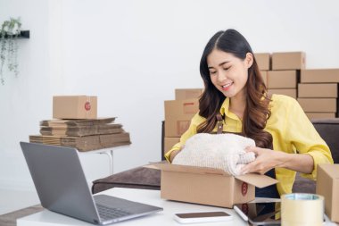 Küçük girişimciler, kahverengi paket kutuları, küçük ev kurma fikirleri olan ürünleri düzenleyerek bir ev kurarlar.