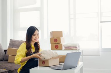 Küçük girişimciler, kahverengi paket kutuları, küçük ev kurma fikirleri olan ürünleri düzenleyerek bir ev kurarlar.