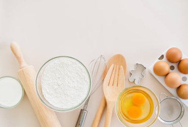 Hafif pembe pastel arka planda yemek pişirmek için gerekli malzemelerin çerçevesi. Fotokopi alanı olan düz bir yemek pişirme. Üst Manzara. Pişirme konsepti. Model.