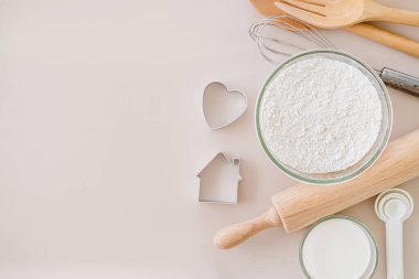 Ekmek hamuru veya kek malzemesi pişirme ve pişirme çerçeve ve mutfak aletleri, un süt yumurtaları. Parlak arkaplan üzerinde çırpı, kurabiye kesici ve un süzgeci metin için kopyalama alanı, düz uzanma