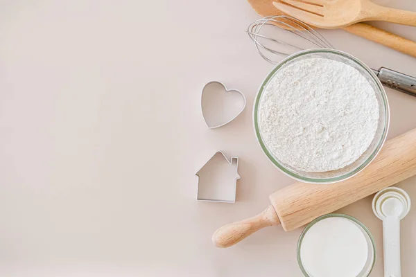 Ekmek hamuru veya kek malzemesi pişirme ve pişirme çerçeve ve mutfak aletleri, un süt yumurtaları. Parlak arkaplan üzerinde çırpı, kurabiye kesici ve un süzgeci metin için kopyalama alanı, düz uzanma