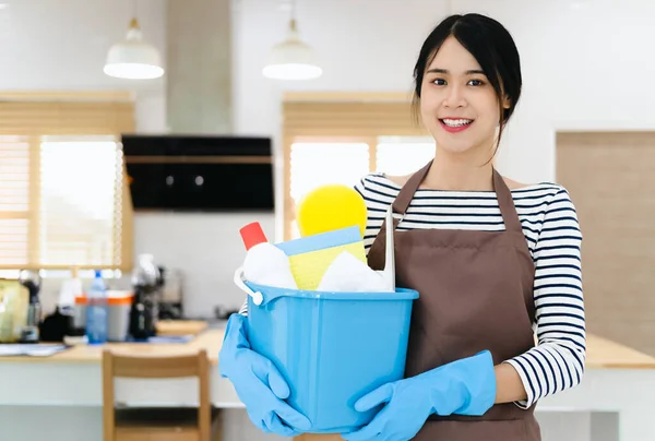 清洁服务 女清洁工微笑的特写 站在厨房里 拿着装有洗涤剂和破布的桶 清洁和清洁的概念 — 图库照片