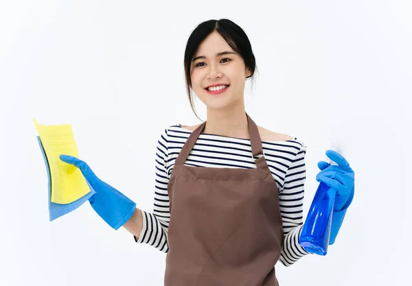 快乐的年轻女子戴着蓝色橡胶手套进行护手 拿着海绵和喷雾器 一边对着相机微笑 一边在白色背景下清扫房子 — 图库照片