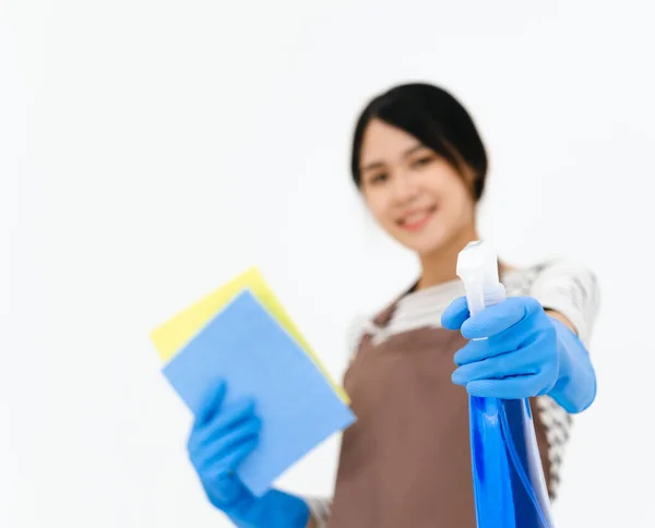 快乐的年轻女子戴着蓝色橡胶手套进行护手 拿着海绵和喷雾器 一边对着相机微笑 一边在白色背景下清扫房子 — 图库照片