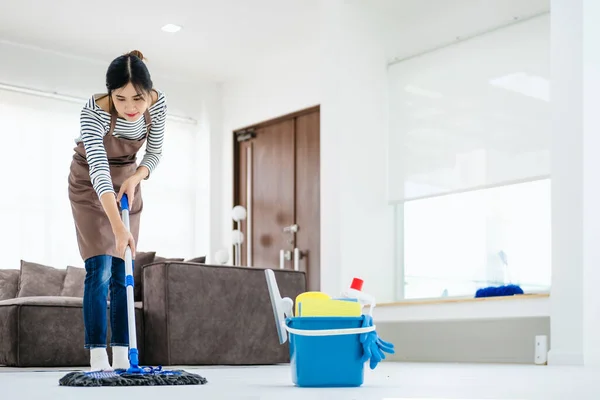 漂亮的年轻女士在围裙上用拖把擦拭地板 打扫房间 腾出空间 积极的家庭主妇整理她的公寓 做家务 专业卫生服务概念 — 图库照片