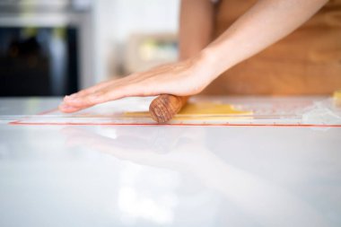 Beyaz arka planda izole edilmiş merdane ve una sahip kadın elleri