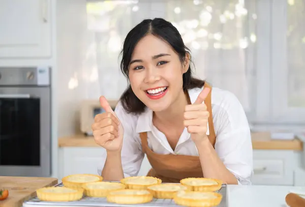 小商业企业家亚洲女人面包店制作水果馅饼 图片中一个快乐的年轻的亚洲女孩厨师在厨房里做菜 摆出大拇指的姿势 — 图库照片