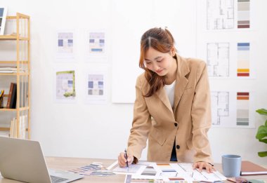 Ofiste çalışan iç mimar. İş yerinde resmi olarak kalem çizim planı tutan mimar.