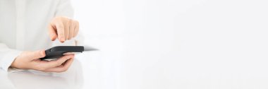 Ofiste akıllı telefon kullanan bir iş kadını. Geniş yatay Panorama örtüsü ve başlık web Banner. Boşluğu kopyala.