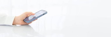 Ekran telefonundaki başparmak, kısa mesaj gönderen kişi, akıllı telefon aydınlatma ofisindeki memur görüntüsü, çevrimiçi internet. Geniş yatay Panorama kapak başlığı Web Banner.