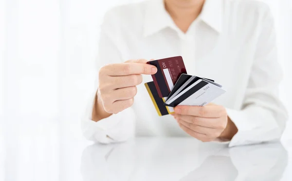 Woman holding several credit cards and choosing a credit card to pay and spend Payment for goods via credit card. Finance and banking concept.