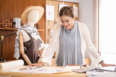 genç bir kadın moda tasarımcısı olarak stüdyonun tasarımları üzerinde çalışan yan görünüm