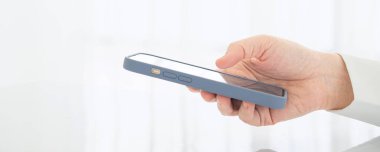 İş adamının cep telefonu kullanarak ve uygulama yoluyla mesaj okuyarak ofis, online çalışma, iş ve teknoloji konseptini kapatması