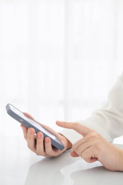 Ofiste cep telefonu kullanarak ekranda parmağı olan kadın