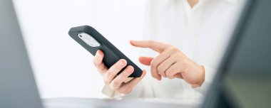 Ofiste cep telefonu kullanarak ekranda parmağı olan kadın