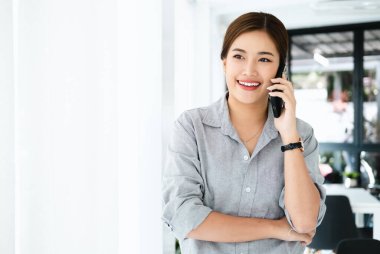 Genç kadın Office konuşurken birileriyle onun cep telefonu süre seyir içine mesafe mutlu yüz ifadesi ile kapatmak.