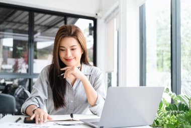 Ofiste çalışan gülümseyen güzel Asyalı kadın fotokopi alanı olan bilgisayarı kullanıyor. İşyeri sahipleri online pazarlama e-pazarlama, ev konseptinden çalışmalar...