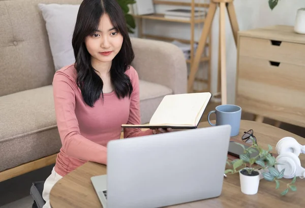 焦点を当てた若いアジアの実業家や学生ノートパソコンの本の学習を保持見て 深刻な女性は オンラインで試験のための研究や準備を行うコンピュータで作業や勉強 — ストック写真