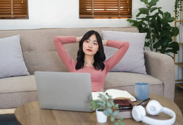Woman enjoying self-directed learning with online educational watching webinar or attending e-class . Young pleased happy cheerful cute  business woman sit indoors in home using laptop computer.