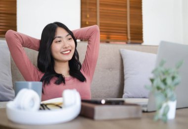 Genç, mutlu, neşeli iş kadını evde dizüstü bilgisayar kullanarak oturuyor. Çevrimiçi eğitim ile kendini yönetmeyi seven bir kadın webinar izler ya da e-sınıfa katılır. .