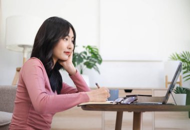 Webinar seyreden, evde ders çalışan, konferans dinleyen, internetten eğitim alan, uzaktan eğitim alan, internet üzerinden çalışan bir kadın..