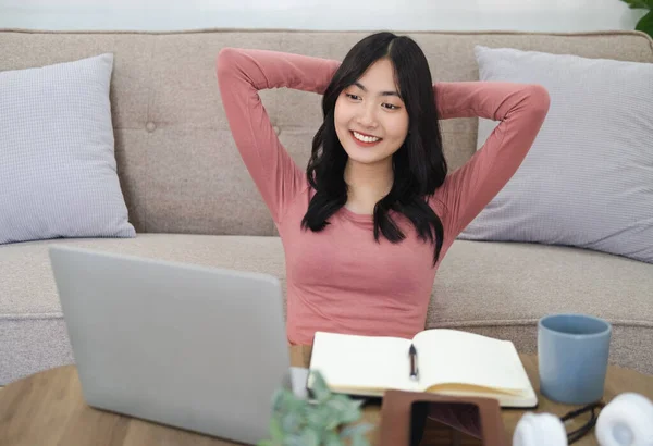Woman enjoying self-directed learning with online educational watching webinar or attending e-class . Young pleased happy cheerful cute  business woman sit indoors in home using laptop computer.