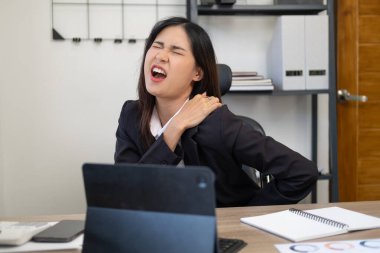 Ofis sendromu konsepti. Genç Asyalı iş kadını bilgisayarla uzun süre çalıştıktan sonra boyun ağrısı çekiyor.