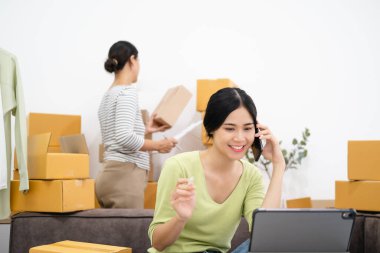 Bir grup genç girişimci online alışveriş ve teslimat konsepti için müşterinin siparişlerini onaylıyor ve kontrol ediyor.