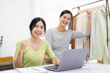Genç Asyalı kadınlar müşterilerden gelen yeni siparişten sonra mutlu olurlar. Asyalı çiftin sürpriz ve şok edici yüzü online mağazasının satışında başarılı oldu. Çevrimiçi satış. Çevrimiçi Alışveriş