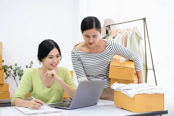 Young woman Online seller owner working for e-business commerce. Business owner checking and packing online order to delivery during sale seasonal.Online Shopping and e-Commerce concept.