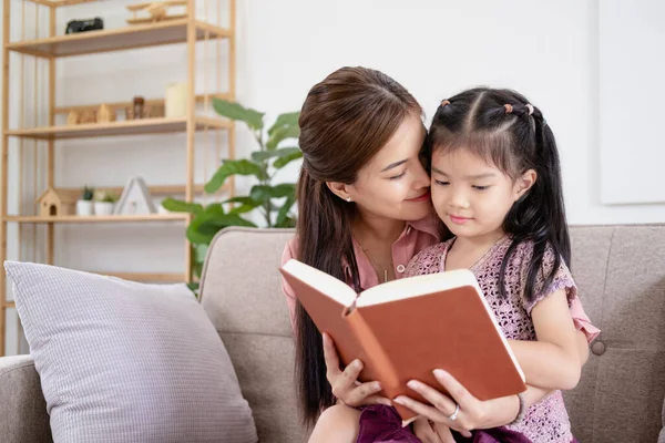Mom and daughter spend time together reading a book. The concept of children\'s development and quality time.