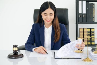 Ofisteki kadın avukat, ahşap masada pirinç tartıyla. Adalet ve hukuk kavramı