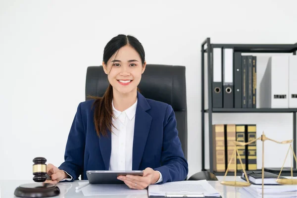 Beautiful woman lawyer working and gavel, tablet, laptop in front, Advice justice and law concept.