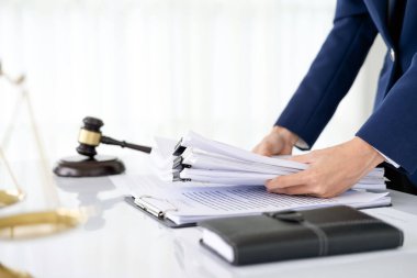 Bir sürü belgesi olan bir ofis çalışanı. Ofiste çalışan, ofis belgelerini düzenleyen bir avukatlık şirketi çalışanı. Önemli belgeler üzerinde çalışma kavramı.