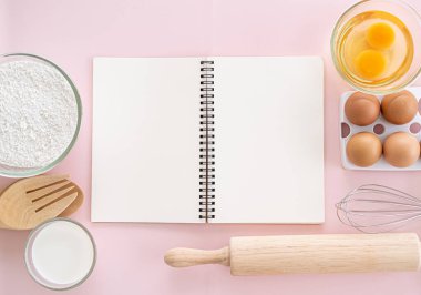 Ahşap mutfak aletleri ve beyaz duvar arkasında pişirme malzemesi tarifi. Kopyalama alanı olan üst görünüm.